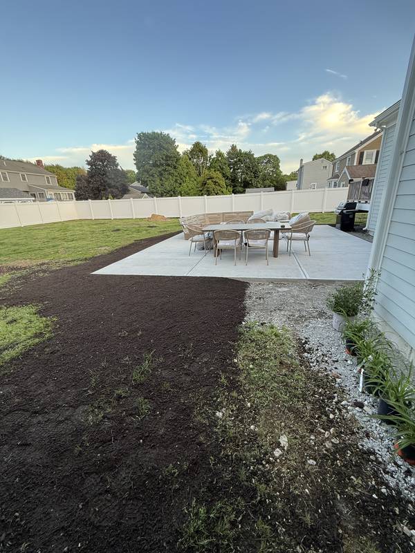 New patio with outdoor dining set and fresh loam edge