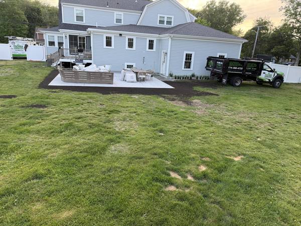 Backyard view of the completed patio and restored lawn