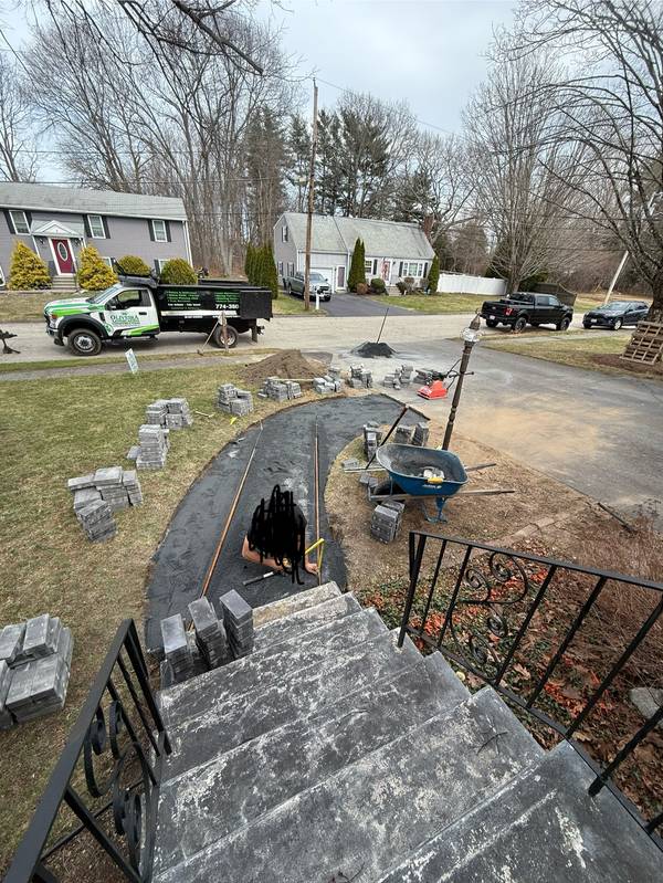 Crew laying pavers along the curved layout