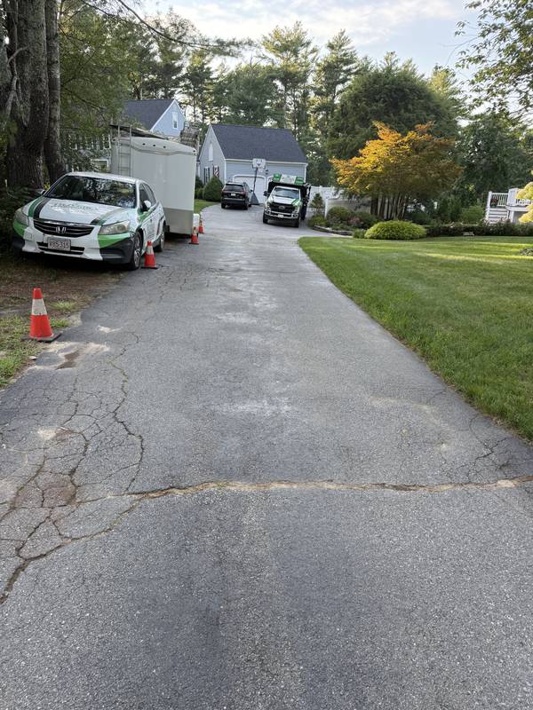 Asphalt driveway meeting the garage before the upgrade