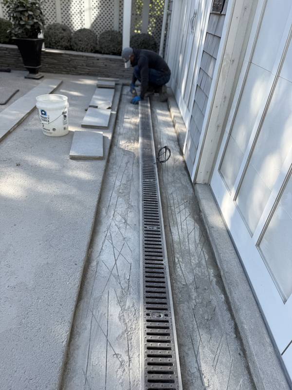 Setting granite pavers around the new trench drain