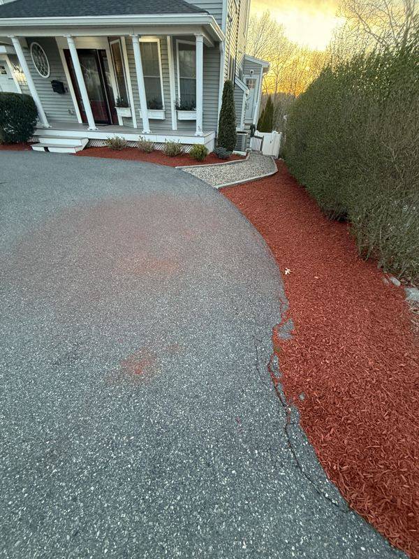 Crisp mulch bed edges hugging the driveway curve