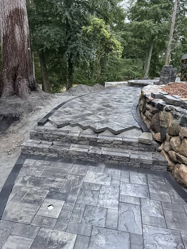 Finished paver steps and landing beside the fieldstone wall