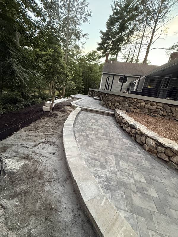 Granite-edged paver walkway winding toward the backyard