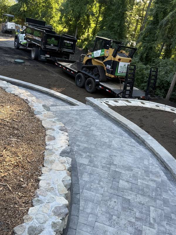 Sweeping paver walkway with granite and fieldstone edging