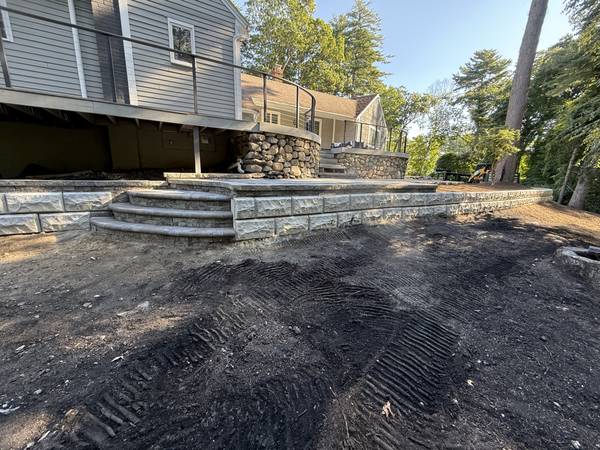 Block retaining wall with granite steps along the new grade