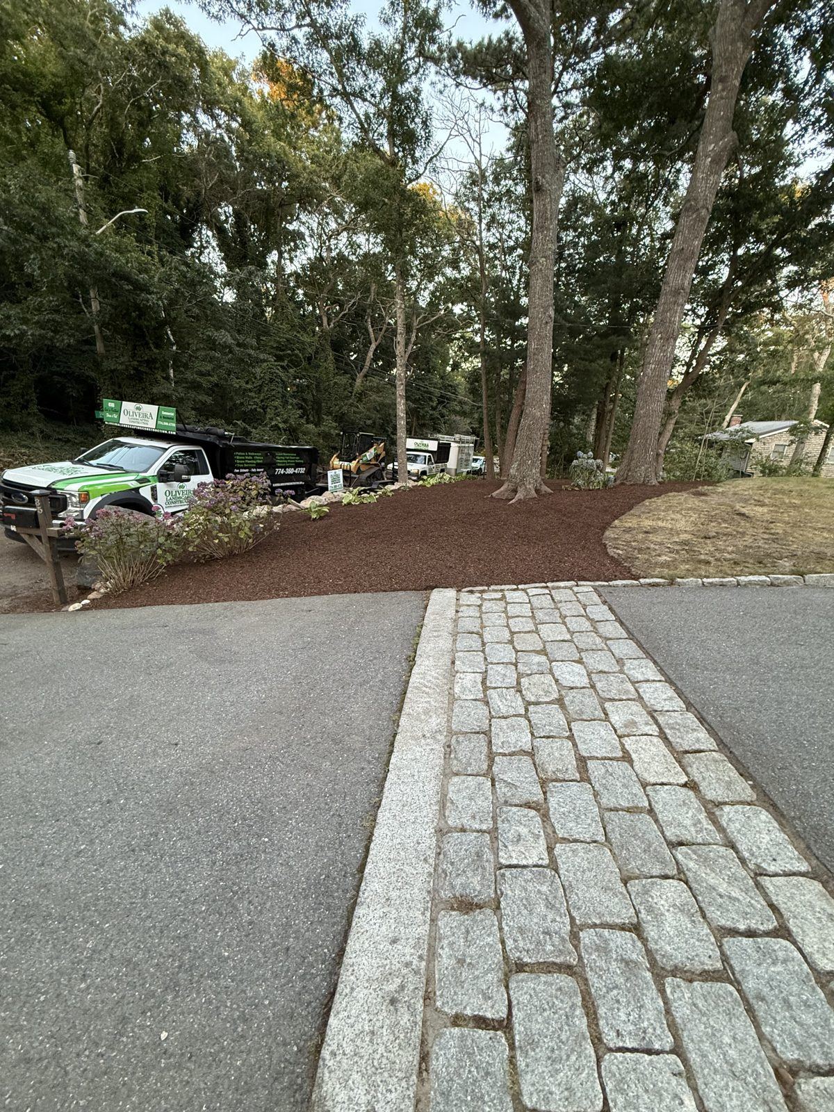 Finished paver walkway with natural stone retaining wall and fresh plantings