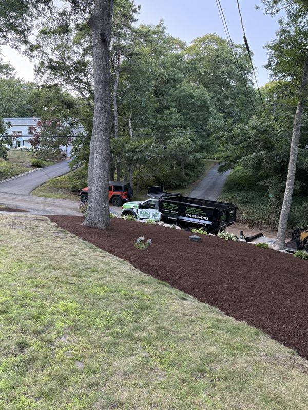 New mulched garden beds lining the driveway approach