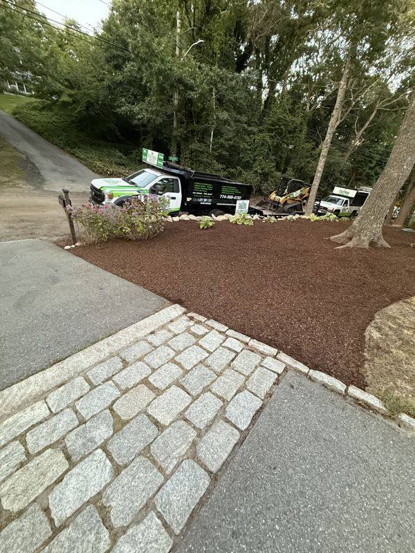 Paver pathway winding through freshly landscaped beds