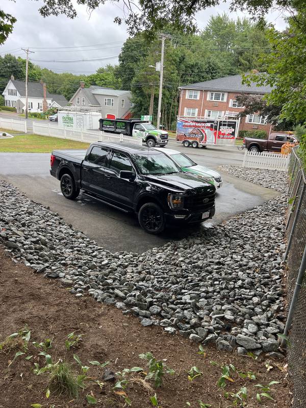 Crushed-stone riprap wrapping the driveway