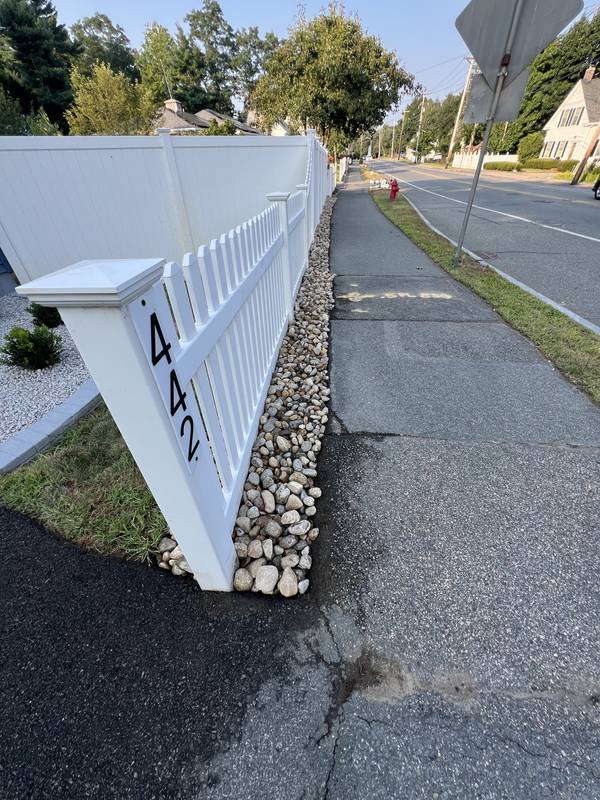 Clean stone edge between fence and sidewalk