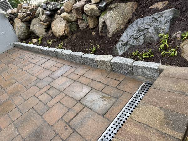 Granite cobblestone border against the boulder wall