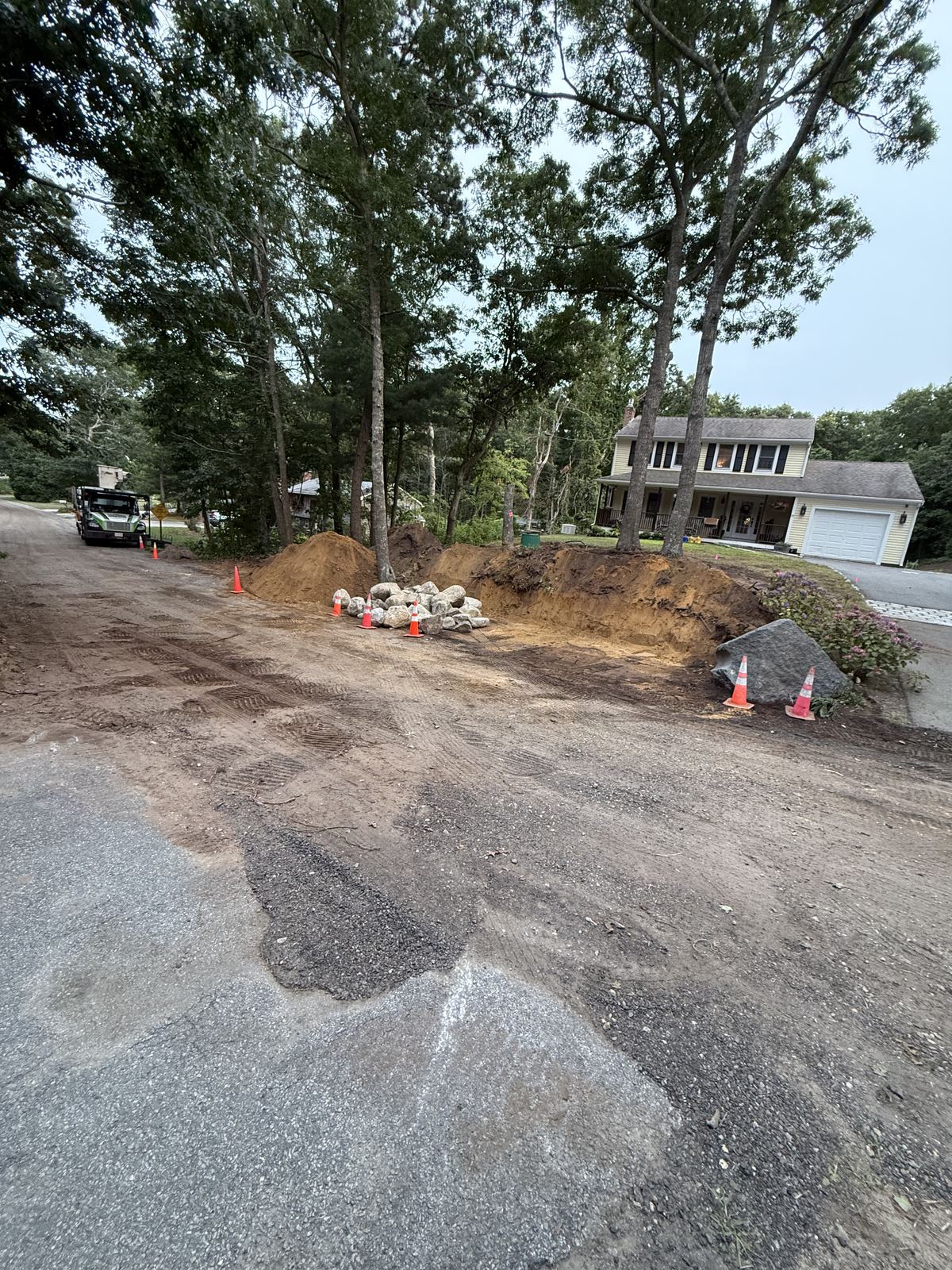 Torn-up driveway edge and slope before regrading
