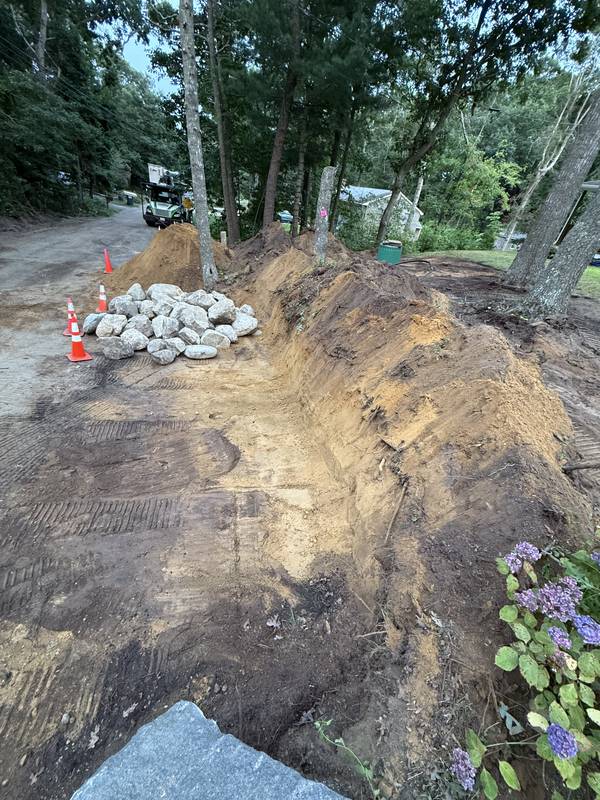 Excavating the slope and staging boulders for the wall