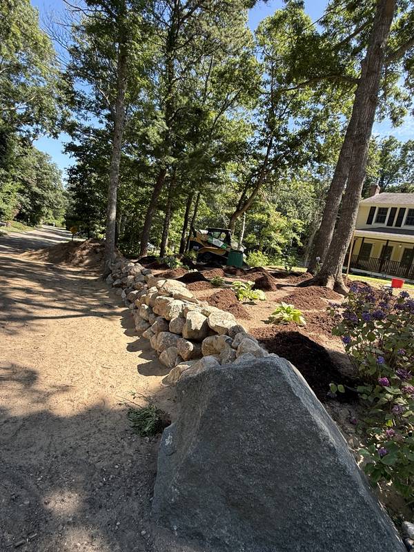 Stacked boulder retaining edge along the driveway
