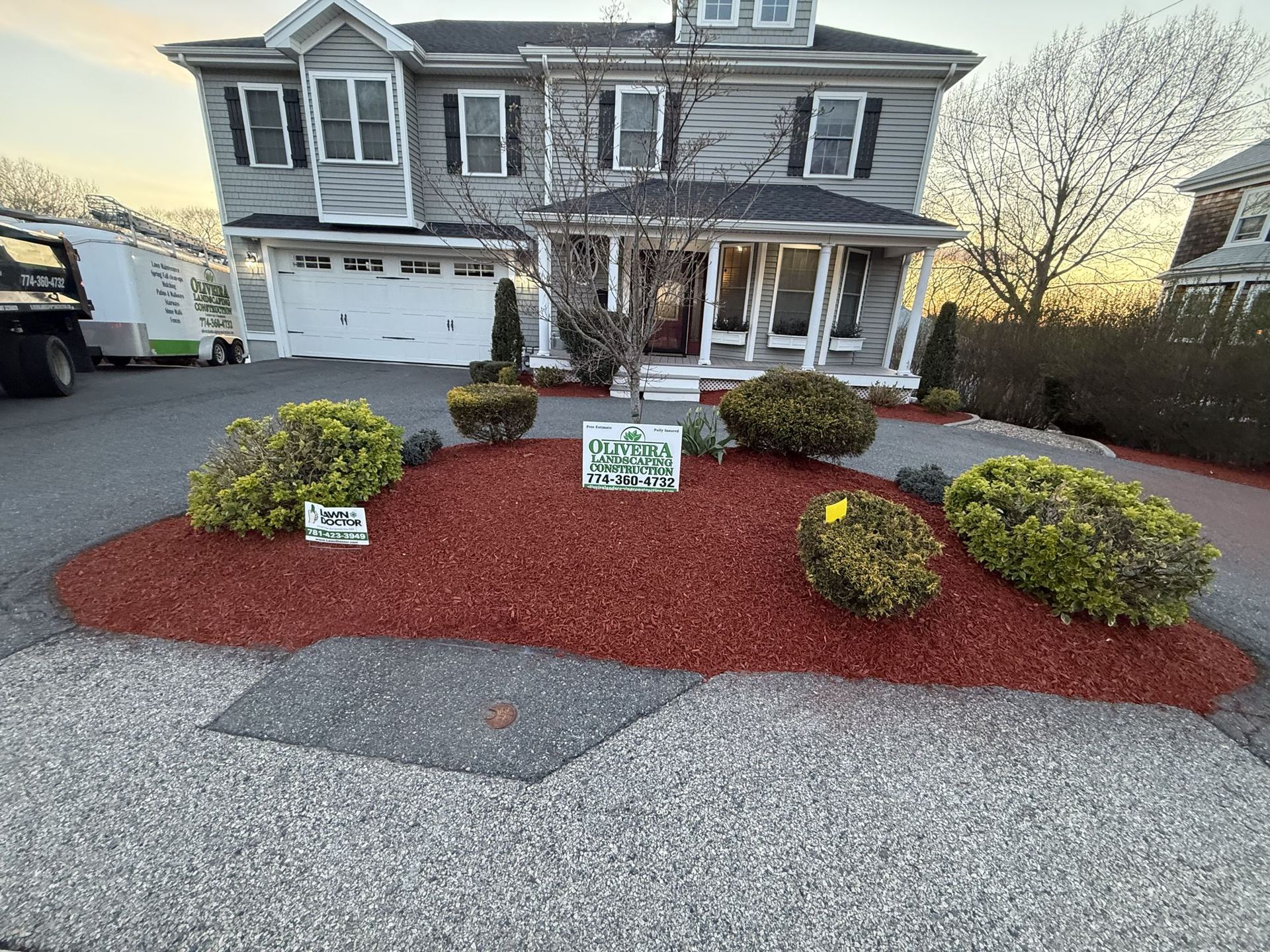 Oliveira Landscaping front-yard transformation with red mulch beds, sculpted shrubs and a crushed-stone driveway on the South Shore of Massachusetts